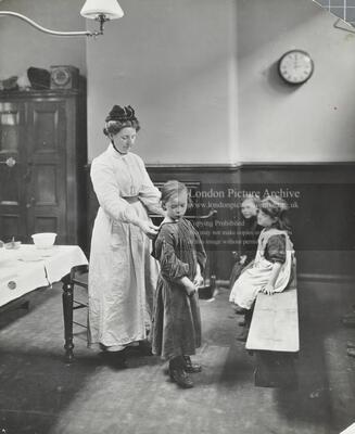 Chaucer L.C.C. Cleansing Station: nurse carries out a preliminary examination of children in the waiting room.